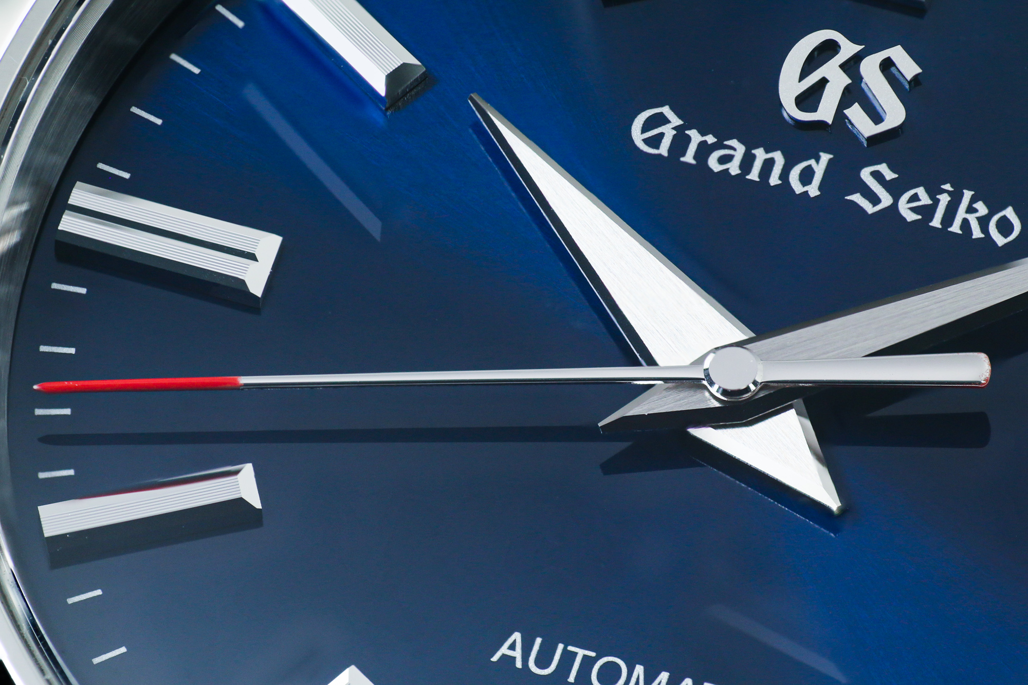 Macro of Grand Seiko SBGR321 wristwatch with a blue dial and red accents.